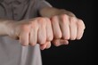 © New Africa - Man showing fists with space for tattoo on black background, closeup