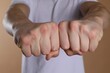 © New Africa - Man showing fists with space for tattoo on beige background, selective focus