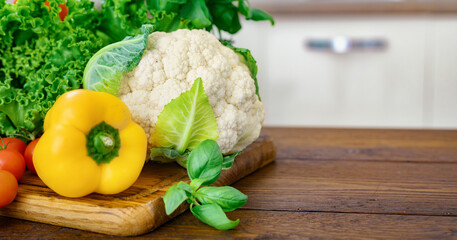 Poster - A set of fresh vegetables for cooking healthy and diet food on a wooden table in a home kitchen with copy space. Healthy food concept