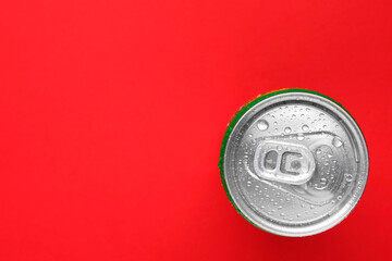 Canvas Print - Energy drink in wet can on red background, top view. Space for text