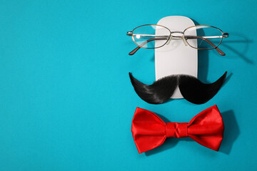 Wall Mural - Flat lay composition with artificial moustache and glasses on light blue background, space for text