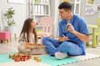 Male pediatrician prescribing inhaler to little girl in clinic