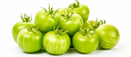 Sticker - A close up of a pile of unripe green tomatoes resting on a clean white surface, showcasing their vibrant color and freshness