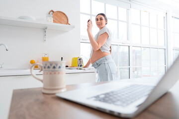 Poster - Young pregnant woman with dried date in kitchen