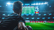 A football coach silhouettes during a match on a football field from the stadium with his back to the camera.
Concept: a fan watching the game, a moment of anticipation.