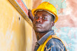 African male worker checking level of the wall with the bubble level tool