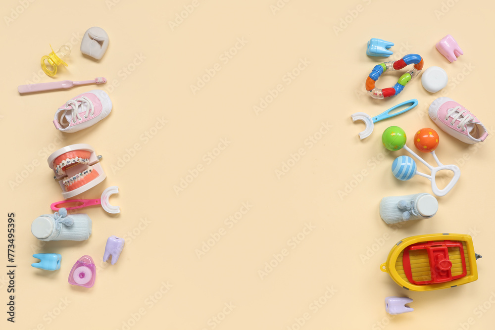 Children's toothbrushes with jaw model and toys on beige background