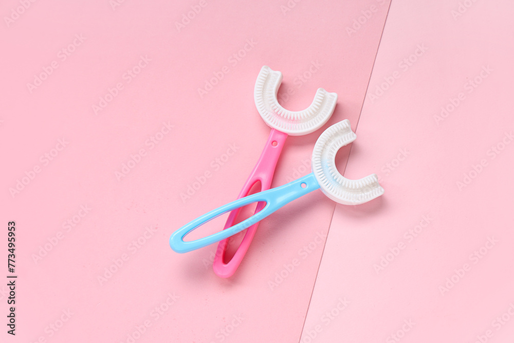 Children's toothbrushes on pink background