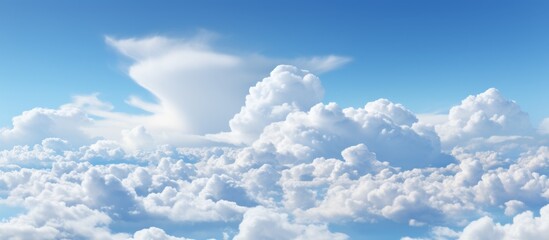 Poster - White fluffy clouds are scattered across the blue sky on a bright and sunny day with a few clouds visible