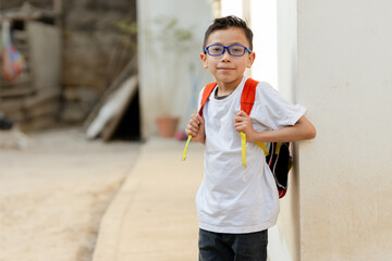 Hispanic boy smiling with his backpack ready to go to school in rural area of Latin America. latin student with backpack. back to school boy at school