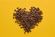 love shape on yellow background making out of coffee beans