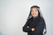 © Aria Armoko - Happy and confident asian muslim man wearing Arab turban sorban standing with crossed arms isolated