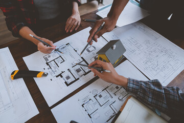 Wall Mural - Team of engineers reviewing blueprints Sketch of a new construction project with engineering tools at office desk. For improvement of house designs in mortgage, rent, sale, real estate