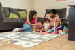 © Alan - Hispanic Family Reading a Learning Book to Their Baby Daughter, Young Latin Couple Enjoying Time with Their Toddler