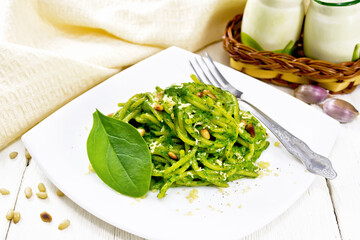 Sticker - Spaghetti with spinach and pine nuts in plate on light board