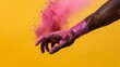 Athlete's hand with purple wrap sprinkling pink powder captures the preparation and vitality in combat sports against a yellow background