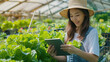 © NooPaew - Smart farm sensor technology smart agriculture concept Smart young asian farmer girl using tablet to check quality and quantity of organic hydroponic vegetable garden at greenhouse in morning.