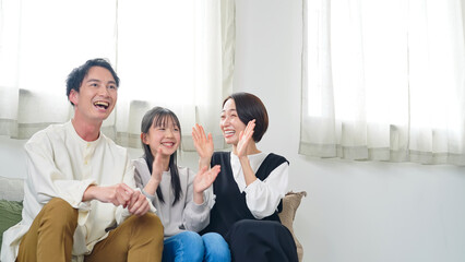 Aufkleber - リビングルームでテレビを見ながら喜ぶ親子