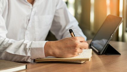 Wall Mural - businessman working at work table,home office desk background, checklist writing planning investigate enthusiastic concept. Male hand taking notes on the notepad.	
