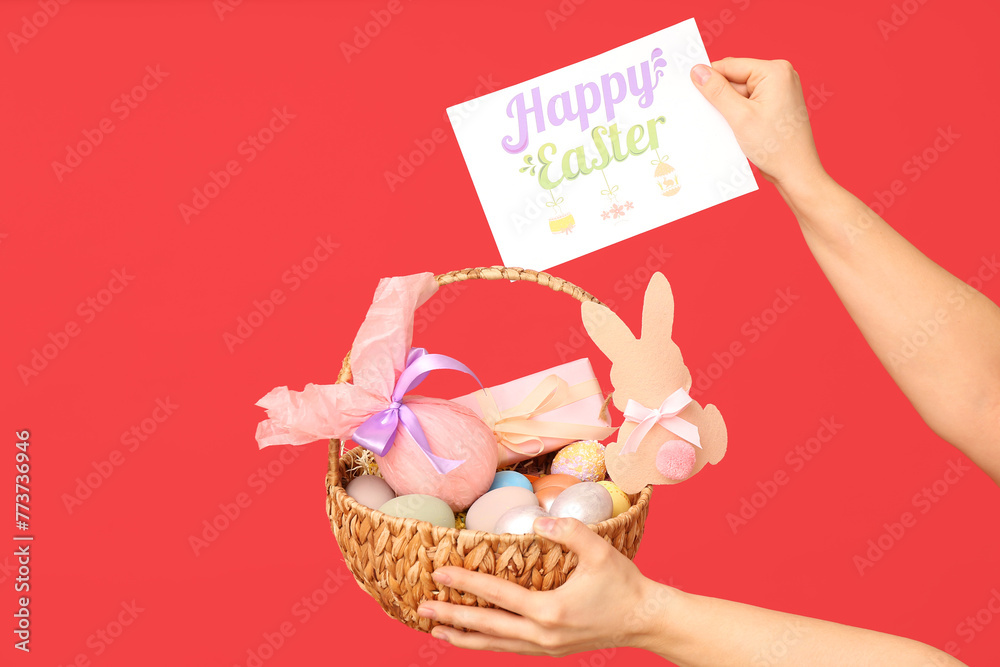 Female hands holding basket for Easter and festive postcard on red background