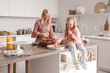 Wall Mural - Little girl with her mother cooking apple pie in kitchen