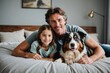 Father and daughter relaxing with australian shepherd on bed at home