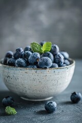 Wall Mural - A bowl of blueberries with a few leaves of mint on top