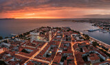Fototapeta Londyn - Zadar, Croatia - Aerial panoramic view of the Old Town of Zadar with Cathedral of St. Anastasia, Church of St. Donatus, yacht marina and a dramatic golden summer sunset at background