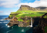 Fototapeta Mosty linowy / wiszący - Faroe Islands waterfall Múlafossur near village Gasadalurron the Island Vágar. Green mountain caost landscape.