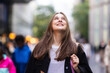 © Westend61 - Smiling young woman with long hair looking up in city