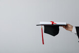 Fototapeta Tulipany - Diploma and hat of a university graduate, on a gray background.