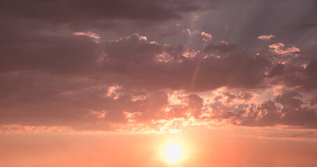 Canvas Print - dreamy sunset sky background with sinking sun and pink lighted clouds