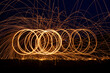 Abstract background of steel wool fireworks. Showers of glowing sparks from spinning steel wool. Steelwool in the night.