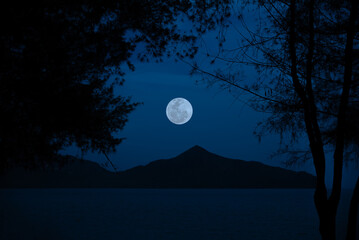 Wall Mural - full moon on sky over sea with mountain in the night.