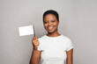 Happy woman holding blank empty flag banner in her hand on gray background
