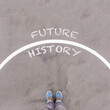 History and Future, text on asphalt ground, feet and shoes on floor