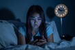 Young woman lying awake at night using her smartphone, symbolizing sleep disruption