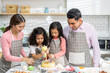 © Art_Photo - Portrait of enjoy happy love asian family father and mother with little asian girl daughter child play and having fun cooking food together with baking cookie and cake ingredient in kitchen