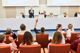 Fototapeta Natura - Woman in audience asking question to speaker at business event