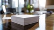 A stack of business cards neatly arranged on a polished wooden desk in a corporate office