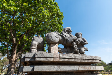 Sticker - A ruined stone sculpture of a figure fighting a lion at the entrance to the ancient Hoysaleshwara temple complex in Halebidu in Karnataka.