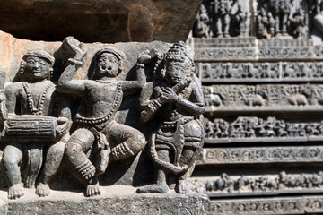 Sticker - Intricate carvings of a group of musicians on the wall of the ancient Hoysaleshwara temple in Halebeedu.