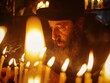 a man with a beard and hat looking at candles