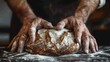 A man is kneading dough for bread. The dough is covered in flour and he is quite thick