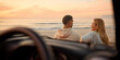 Rear View Of Couple Chatting By Car At Beach Watching Sunrise Together Viewed Through Windshield