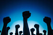 Silhouettes of male fists raised in the air, symbolizing the labor movement and workers' union strike fighting for their rights and better working conditions