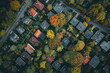 Aerial view showcasing a neighborhood in autumn with colorful trees, houses, and streets