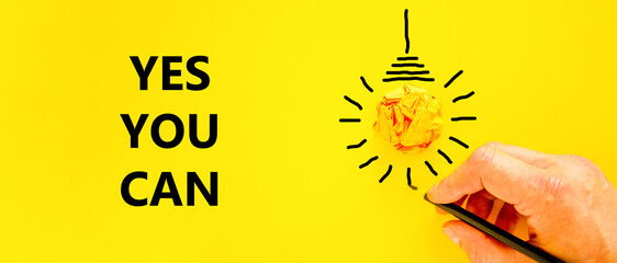 Wall Mural - Motivational Yes you can symbol. Concept words Yes you can on beautiful yellow paper. Beautiful yellow background. Light bulb. Businessman hand. Business motivational Yes you can concept. Copy space