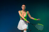 Fototapeta Sport - Squash player on a squash court with racket. Man athlete with racket on court with neon colors. Sport concept. Download a high quality photo for the design of a sports app or betting site.