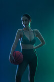 Fototapeta Sport - Basketball player. Portrait of woman with a basketball ball in studio. Sports betting concept. Game day.